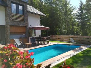 a swimming pool in the backyard of a house at Apartmaji Hiša Katja-Privat wellness in Kranjska Gora
