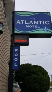 a sign for the atlantic motel next to a building at Atlantic Motel in Point Pleasant Beach