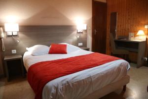 a bedroom with a large bed with a red pillow at Hôtel l'Edelweiss in Châtel