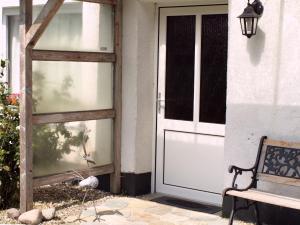 a door to a house with a bench next to it at Landhaus Kranichwiese in Göhren-Lebbin +38 photos