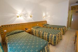 a hotel room with three beds in a room at Real Caparica Hotel in Costa da Caparica