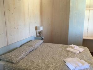 1 dormitorio con 1 cama con 2 toallas en Agriturismo Le Rondini Di San Bartolo, en San Vincenzo