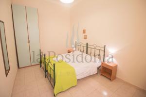 um quarto com uma cama com um cobertor amarelo em La Posidonia em Donnalucata