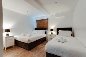 
a hotel room with two beds and two lamps at The Print Works Apartments in Liverpool
