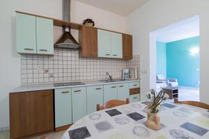 a kitchen with white cabinets and a table with a table cloth at Apartments Kori in Funtana