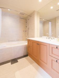 a bathroom with a tub and a sink at Hotel Shiki Utsubo Park in Osaka