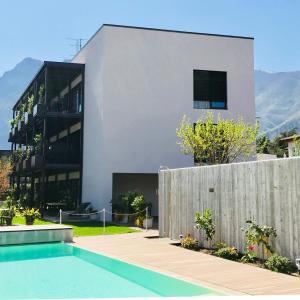 a house with a swimming pool in front of a building at SOLeARIA residence in Riva del Garda