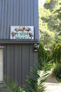 a iron house sign on the side of a building at Moon House in Diamond Creek