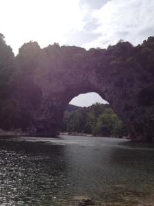 eine große Steinbrücke über einen Wasserkörper in der Unterkunft Hotel Des Sites in Salavas