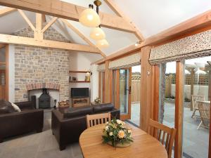 a living room with a fireplace and a table at Pear Tree Cottages in Wedmore