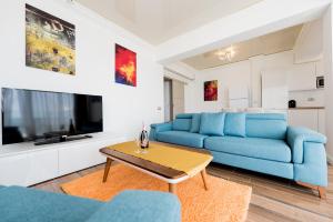 a living room with a blue couch and a table at White Tower Mamaia in Mamaia