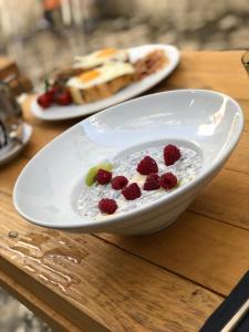 a bowl of yogurt with raspberries on a table at Bubalus Boutique Rooms in Trogir