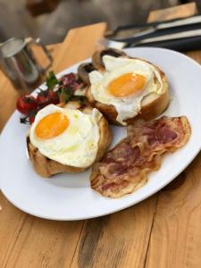 a plate of eggs and bacon on a table at Bubalus Boutique Rooms in Trogir