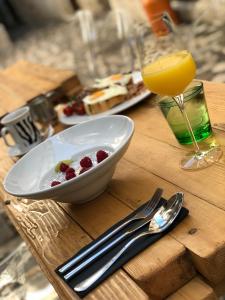 a table with a bowl of fruit and a glass of juice at Bubalus Boutique Rooms in Trogir