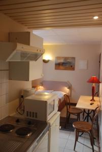 a kitchen with a microwave and a kitchen with a table at Residence De La Tour Paris-Malakoff in Malakoff