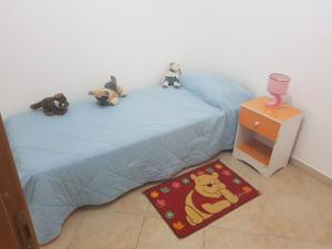 een slaapkamer met een bed met knuffels erop bij Villa Aurora Per Vacanze in Palermo