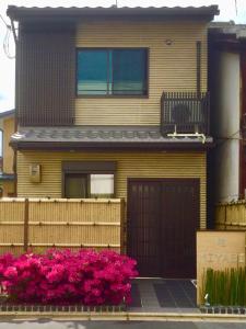 dom z różowymi kwiatami przed nim w obiekcie Miyabi w mieście Kioto