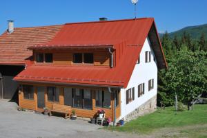 a house with an orange roof with a horse in front at Ferienhaus "Lisa´s Häusl" in Neuschönau