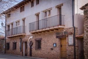 un edificio de piedra con 2 balcones en un lateral en Hotel Rural Casa La Era en Galve