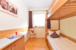 Kleines Zimmer mit einem Etagenbett und einem Schreibtisch. in der Unterkunft Landhaus Hubert's Hüs in Oberjoch