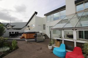 eine Terrasse mit einem Herd und Stühlen vor einem Haus in der Unterkunft Luxury Villa Reykjavík in Reykjavík