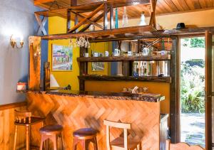 a bar with wooden stools in a room at Refúgio Ecológico Amadamata in Nova Friburgo