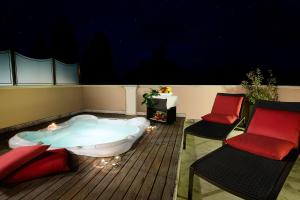 福利尼奧的住宿－Boutique Hotel & Spa Villa dei Platani，甲板上的浴缸,配有两把椅子