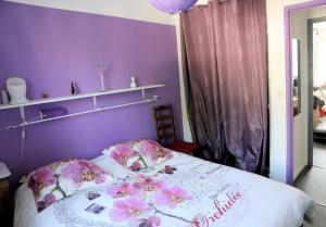 een paarse slaapkamer met een bed met bloemen erop bij Cosy Nîmes in Nîmes