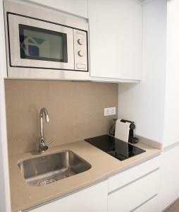 cocina con fregadero y microondas en Apartamentos Core Suite Sevilla, en Sevilla