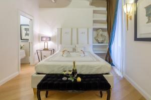 1 dormitorio con 1 cama grande y banco negro en StarHome Pantheon, en Roma