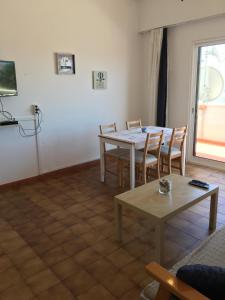 een woonkamer met een tafel en stoelen en een raam bij Vila Praia Apartment in Albufeira