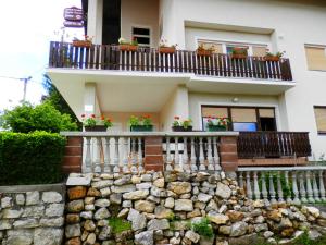 a house with potted plants on the balcony at Apartment Marija Zupan in Rakovica