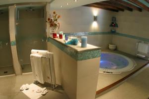 
a bathroom with a tub and a sink at Hotel & Spa Casa Irene in Arties
