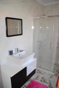 a white bathroom with a sink and a shower at Casa de Penedones in Penedones