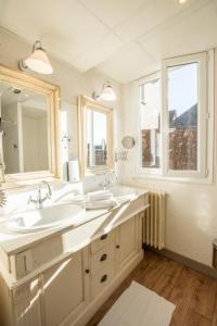 a bathroom with two sinks and a large mirror at Contact Hôtel Le Relais de Vellinus in Beaulieu-sur-Dordogne