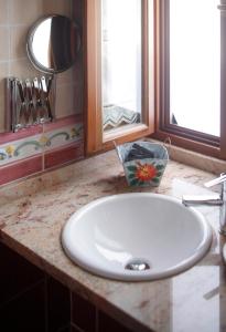 a white sink in a bathroom with a mirror at O Plantio in Porto de Espasante