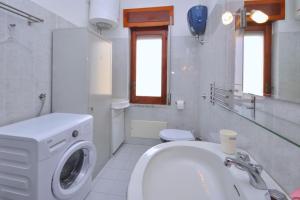 パエストゥムにあるCasa Venereの白いバスルーム(洗濯機、シンク付)