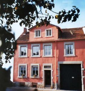 Casa roja grande con ventanas blancas y puerta en Gästehaus Stadtmitte, en Merzig