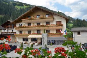 a large building with flowers in front of it at Hotel Alpenblick in Sarntal