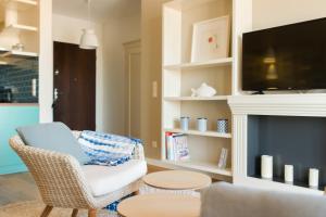 a living room with a chair and a fireplace at CITYSTAY BraBank Gdansk Apartment in Gdańsk