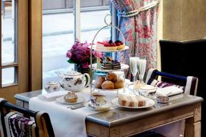 a table with food and cups and plates of food at Covent Garden Hotel, Firmdale Hotels in London
