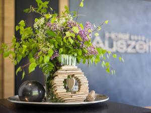 Eine Vase mit Blumen auf einem Teller in der Unterkunft Hotel Auszeit in Pertisau