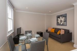 a living room with a table and a couch at One bedroom High street kensington Apartment in London