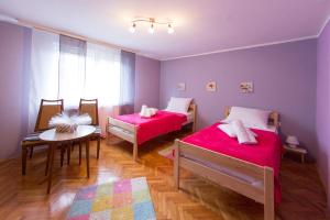 Camera con 2 letti e un tavolo con un tavolino sidx sidx. di Apartman Antea a Otočac