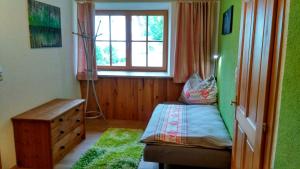 Habitación pequeña con cama y ventana en Ferienwohnung Maringer, en Ungenach