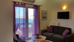 uma sala de estar com um sofá e uma porta de vidro deslizante em Amazing Sea View Apartment em Chania Town