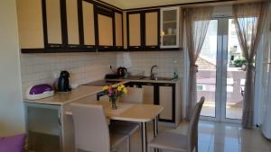 eine Küche mit einem Tisch und Stühlen sowie einem Fenster in der Unterkunft Amazing Sea View Apartment in Chania