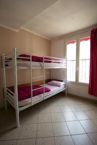 two bunk beds in a room with two windows at Auberge Internationale des Jeunes in Paris
