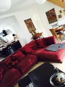 a living room with a red couch and a table at La Romanée in Sallaumines