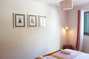 フンシャルにあるThe Seaside Apartmentのベッドルーム1室(ベッド1台付)が備わります。壁に3枚の写真が飾られています。